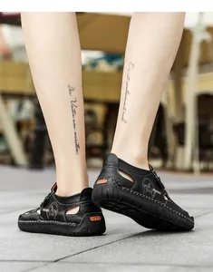 Close-up of black genuine leather men's loafers with cutout detail and rubber sole