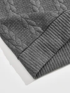 Close-up of the heavy jacquard texture and ribbed hem on a grey men's sweatshirt