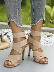 Detailed view of women's beige high-heeled sandals with elastic straps and zipper