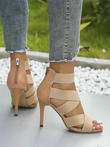 Nude high heel sandals featuring elastic straps and a functional back zipper detail
