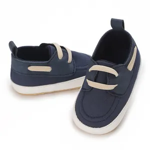 Vista dettagliata di scarpe da neonato in tela blu navy con suole bianche morbide.