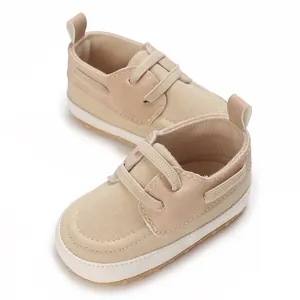 Dettaglio di scarpine in tela beige per neonato con lacci elastici e suola morbida