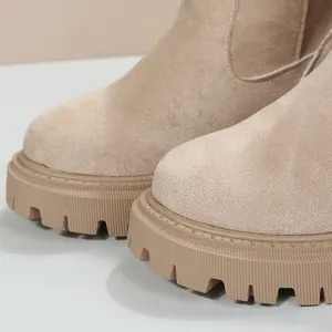 Gros plan détaillé sur des bottes de neige en daim beige avec semelles épaisses
