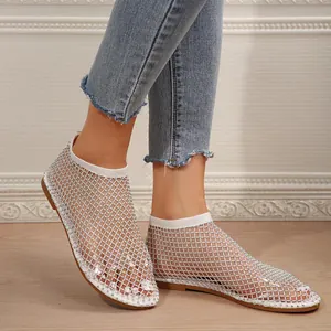 Detailed view of white mesh flat sandals with sparkling rhinestone embellishments