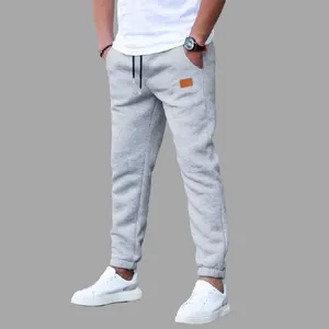 Detailed view of men's stylish grey jogger sweatpants with adjustable black drawstring waist