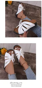 Detailansicht der weißen Peep-Toe-Keilsandaletten mit hohl geschnittenem Schleifendesign.