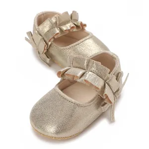 Detail view of gold baby princess shoes with metallic shimmer and ruffle trim