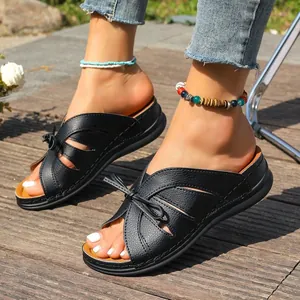 Detailansicht der schwarzen Damen-Keilsandalen mit Cut-out-Design und Schleife