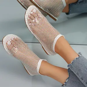 Close-up of white mesh rhinestone flat sandals with round toe and hollow design