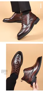 Primer plano de botas de invierno para hombre en cuero marrón con estampado de cocodrilo