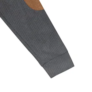 Detailed view of gray ribbed men's sweatshirt sleeve featuring a brown elbow patch