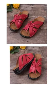 Detailansicht roter Sandalen mit Ausschnitt-Design und Schleife auf Holzhintergrund.