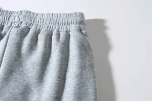 Detail of grey men's sports pants with elastic waistband and high-quality knit fabric