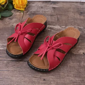 Detailansicht roter Damensandalen mit Lochmuster-Design und einer süßen Schleife.