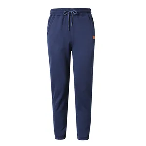 Detailed view of men's dark blue joggers featuring elastic waist with drawstring