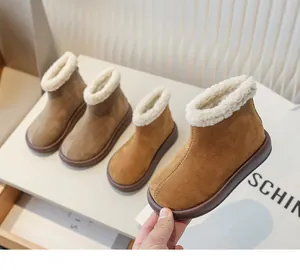 Macro view of brown suede girls winter snow boots featuring cozy thick faux fur lining