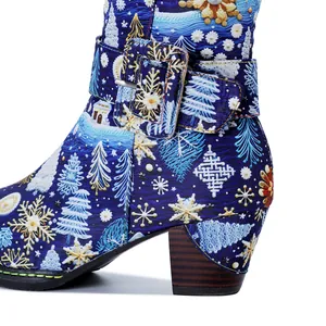Detail shot of Christmas snowflake and tree patterns on retro blue chunky heel boots