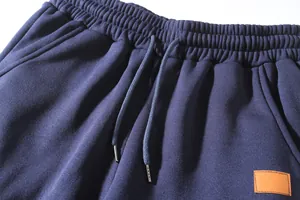 Close-up detail of navy blue sports trousers featuring elastic waistband and drawstring.