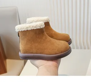 Close-up of children's brown suede snow boots with plush lining and back zipper