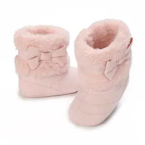 Macro view of pink baby winter boots with soft faux fur trim and cute bow detail