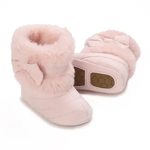 Detail view of pink infant winter boots with soft faux fur trim and cute bow accent