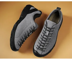 Nahaufnahme grauer Wildleder-Outdoor-Wanderschuhe für Herren mit markantem Schnürsystem-Design