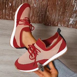 Vista dettagliata delle sneakers da donna in maglia rossa e beige con lacci sportivi