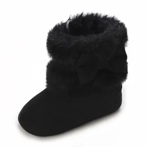 Detail view of cozy black faux fur baby boots featuring a stylish bow and soft soles