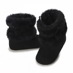 Close-up of black baby winter boots with soft faux fur lining and a cute bow