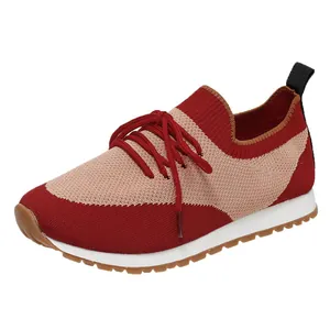 Dettaglio scarpe sportive da donna in maglia bicolore rosso e beige con lacci rossi