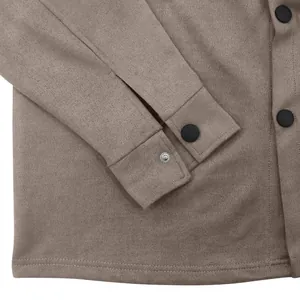 Detailansicht der Wildledertextur und schwarzen Druckknöpfe an der Manschette einer Herrenjacke.