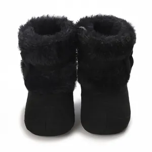 Detailed view of black fuzzy infant winter boots featuring soft sole and bow accent