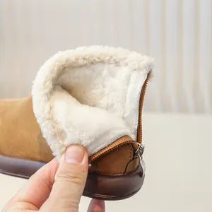 Close-up of toddler girls warm brown suede snow boots with white plush lining and rear zipper