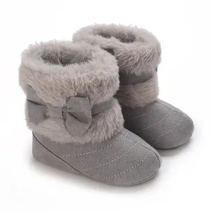 Close-up view of grey baby winter boots with faux fur trim and cute bow detail.