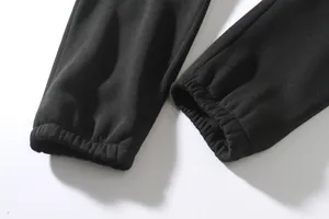 Detailed close-up view of the elasticated ribbed cuffs on men's black casual jogger pants.