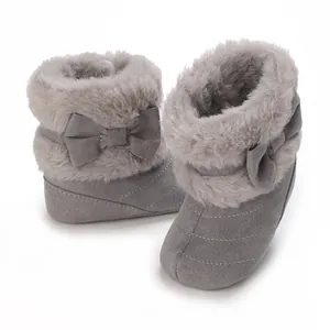 Close-up detail of warm grey baby boots with soft faux fur trim and cute bow accent