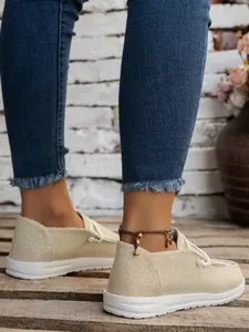 Detailed macro view of beige canvas casual shoes with textured fabric and white sole
