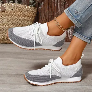 Dettaglio delle scarpe da ginnastica in maglia da donna con lacci e bicolore