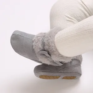 Detailed view of gray infant winter boots with plush faux fur collar and cute bow