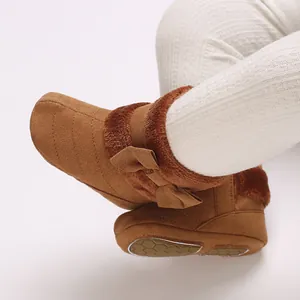 Detailed view of brown baby winter boots featuring plush faux fur trim and cute bow accent