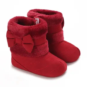Close-up of red baby winter boots with plush fur lining and a charming bow detail