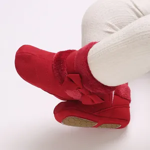 Detailed close-up of red baby winter boots featuring soft fur lining and a decorative bow