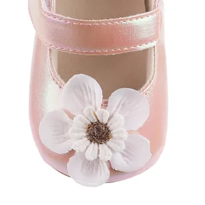 Nahaufnahme eines rosa perlmuttfarbenen Baby-Prinzessin-Schuhs mit weißer Stoffblume