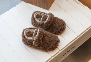 Vue détaillée de la texture pelucheuse des chaussons d'hiver marron pour enfants