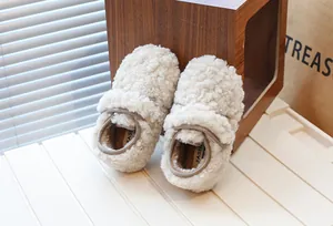 Gros plan de mocassins en peluche crème pour enfants avec doublure en polaire chaude