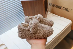 Vue détaillée de chaussures en peluche pour enfants, marron chaud, texture douce.