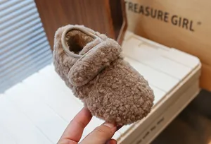 Vue détaillée de chaussures d'hiver douillettes en polaire marron pour tout-petits avec scratch.