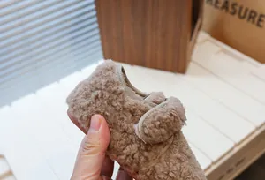 Détail en gros plan de la fausse fourrure brune douce et de la bride velcro pour enfants.