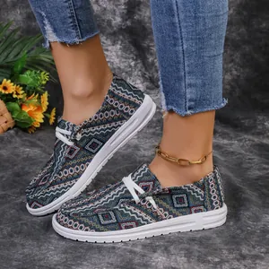 Side view detail of ethnic geometric pattern canvas loafers on a model wearing denim