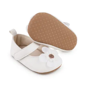 Detailansicht weißer Baby-Lauflernschuhe mit Stoffblume und brauner Gummisohle